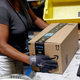 An Amazon worker applies tape to a package before shipment at an Amazon fulfillment center in Baltimore.